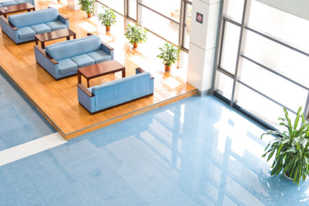 Canapés de couleur bleu ciel se trouvant dans le lobby d'un immeuble à bureaux baigné de lumière naturelle